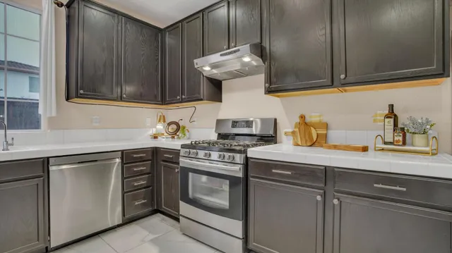 a kitchen with stainless steel appliances granite countertop a sink stove and cabinets