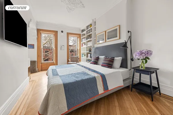 a bedroom with a bed and wooden floor
