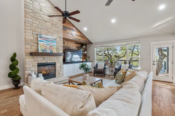 a living room with furniture a large window and a fireplace