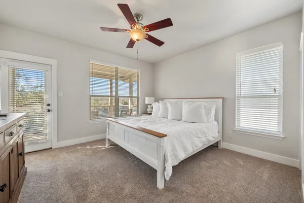 a spacious bedroom with a large bed and a chandelier