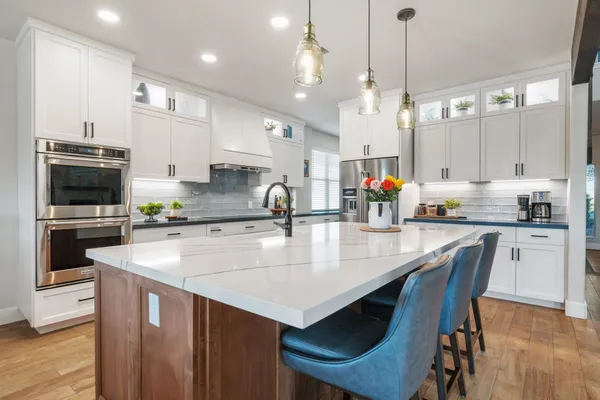 a kitchen with a dining table chairs stainless steel appliances and cabinets