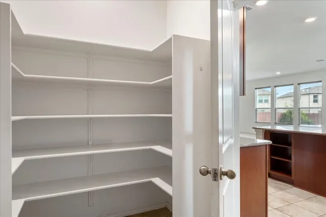 a view of walk in closet with empty racks
