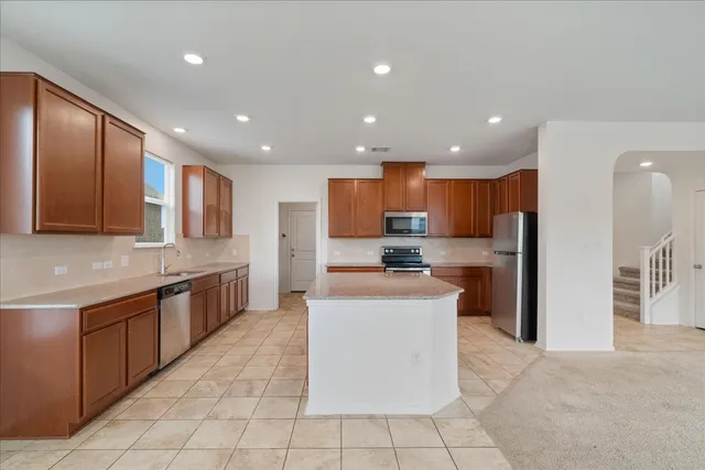 a large kitchen with stainless steel appliances lots of counter top space