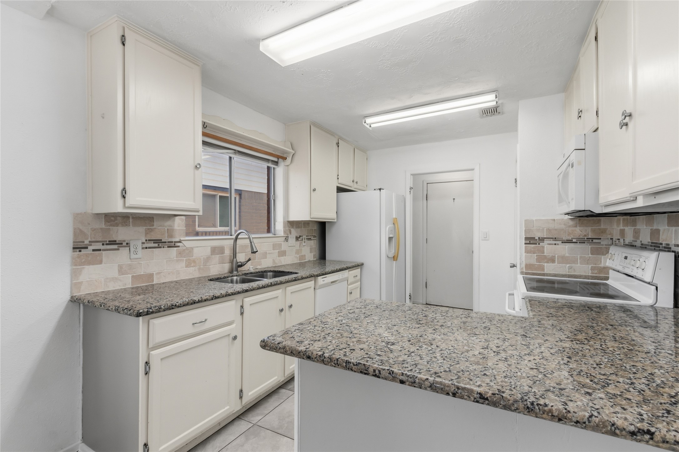 10922 Fallbrook Drive Houston, TX 77064 - Photo 10 of 28 A closer view of the kitchen shows a new stainless faucet with a double sink and a window to keep up with the weather.