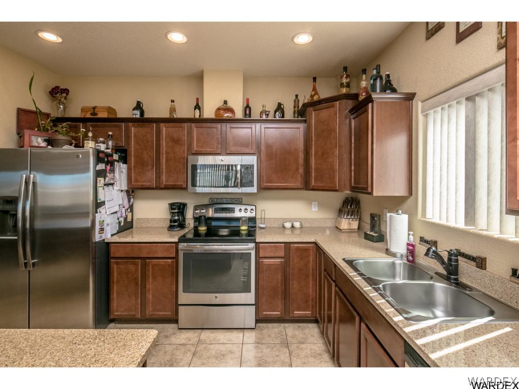 4909 North Neal Ranch Road Kingman, AZ 86401 - Photo 12 of 36 a kitchen with stainless steel appliances granite countertop a sink stove and refrigerator