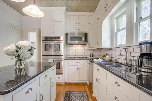a kitchen with stainless steel appliances a microwave sink stove and cabinets