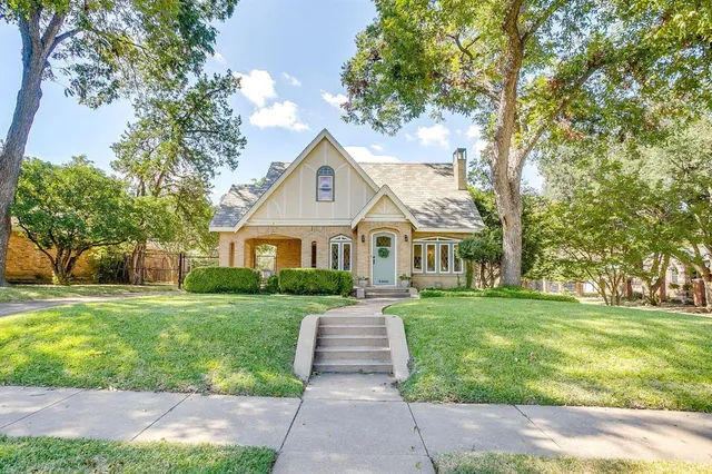 a front view of a house with a yard and potted plants