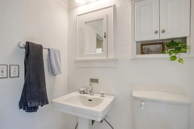 a bathroom with a sink toilet and mirror