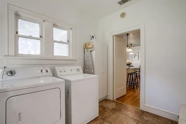 a view of washer and dryer with bathroom in the background