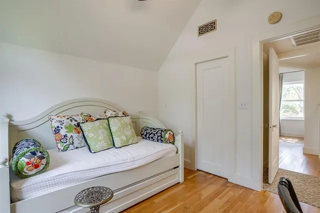 a bedroom with a bed and wooden floor