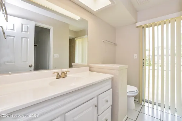 a bathroom with a sink a toilet and a large mirror