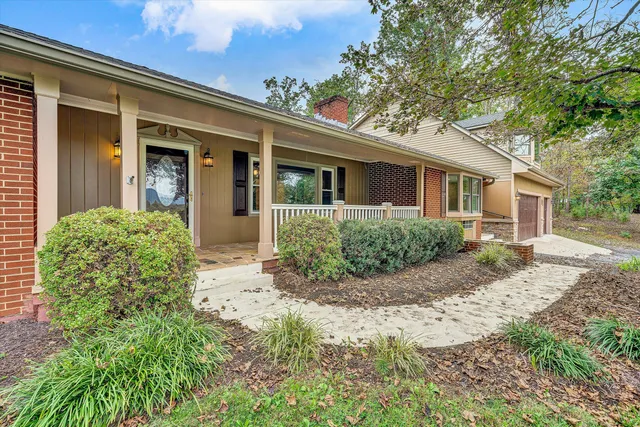 an empty room with fireplace wooden floor chandelier fan and windows