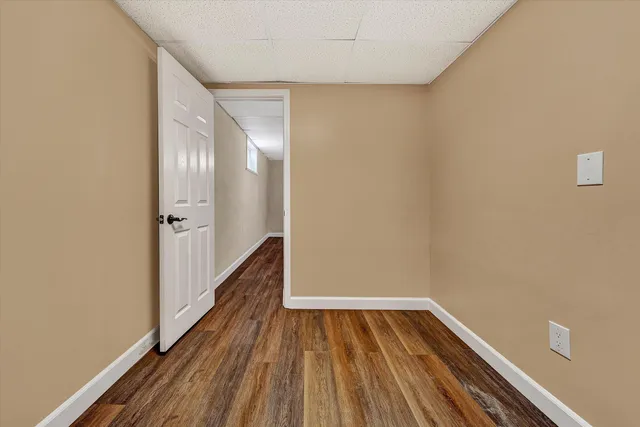 a view of swimming pool with lawn chairs and large trees