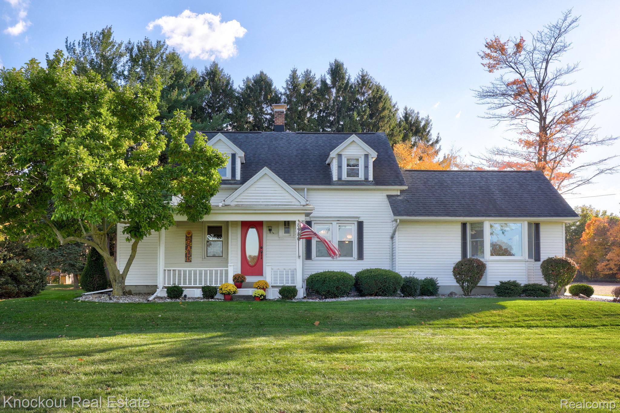 8980 Curtis Road Frankenmuth, MI 48734 - Photo 2 of 56 Cape cod-style house with a porch, a front yard, a chimney, and roof with shingles