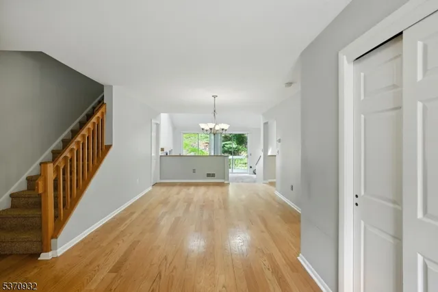 a view of a room with wooden floor staircase and a living room
