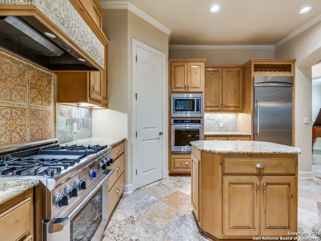 a kitchen with stainless steel appliances granite countertop a stove and a refrigerator