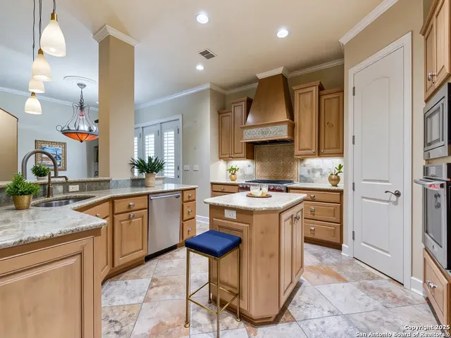 a kitchen with stainless steel appliances granite countertop a stove refrigerator sink and cabinets