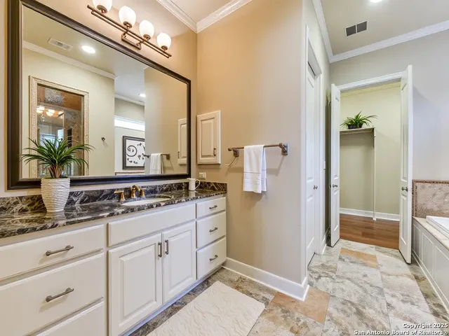 a bathroom with a granite countertop sink a mirror and a shower