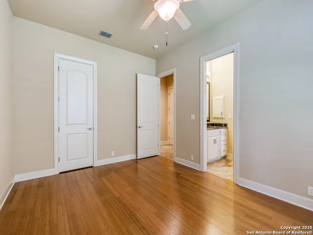 an empty room with wooden floor and closet area