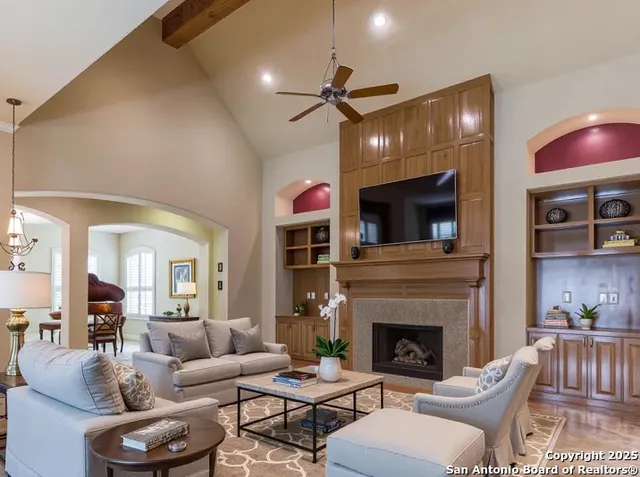 a living room with furniture a fireplace and a flat screen tv