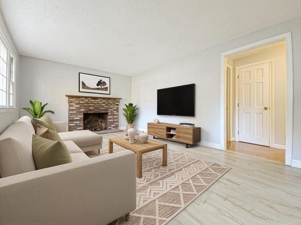 49 St Marks Road Falmouth, MA 02536 - Photo 20 of 38 a living room with furniture a fireplace and a flat screen tv
