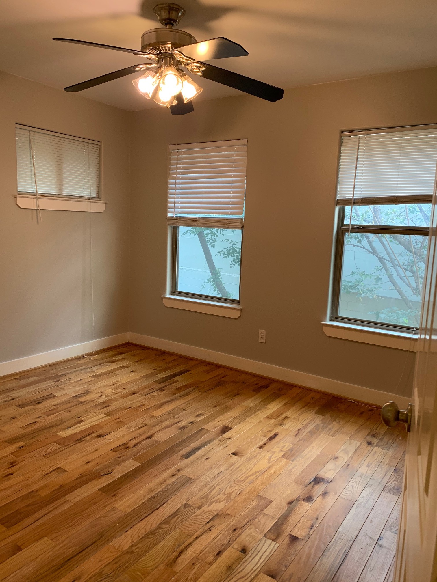 3207 Hampton Road, Unit B Austin, TX 78705 - Photo 4 of 7 a view of an empty room with wooden floor and a window