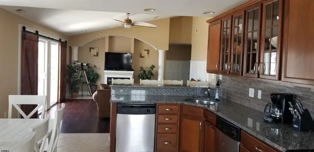 a kitchen with stainless steel appliances granite countertop a sink refrigerator and cabinets
