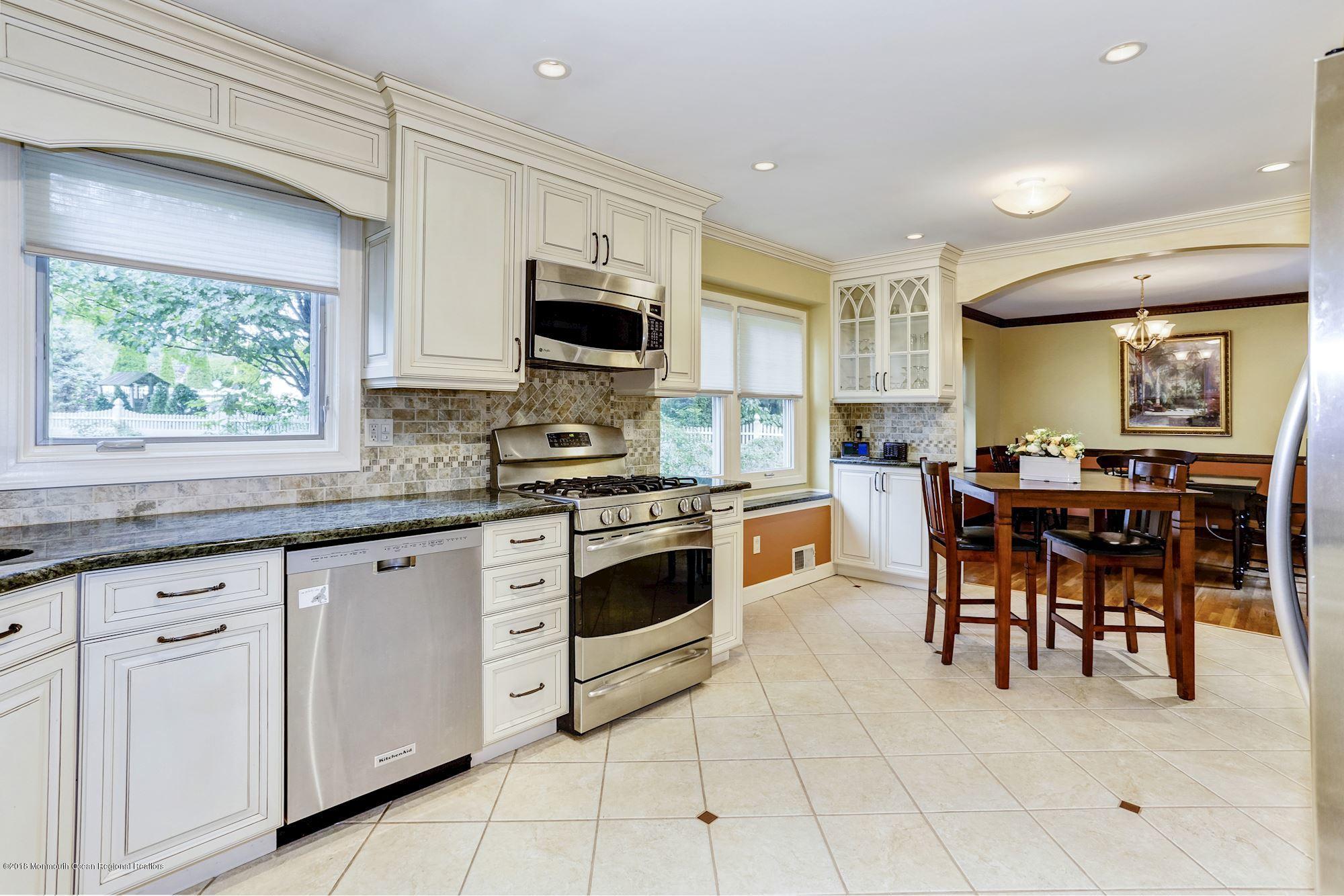 3 East Point Road Lincroft, NJ 07738 - Photo 15 of 42 a kitchen with stainless steel appliances granite countertop a stove top oven a sink a dining table and chairs