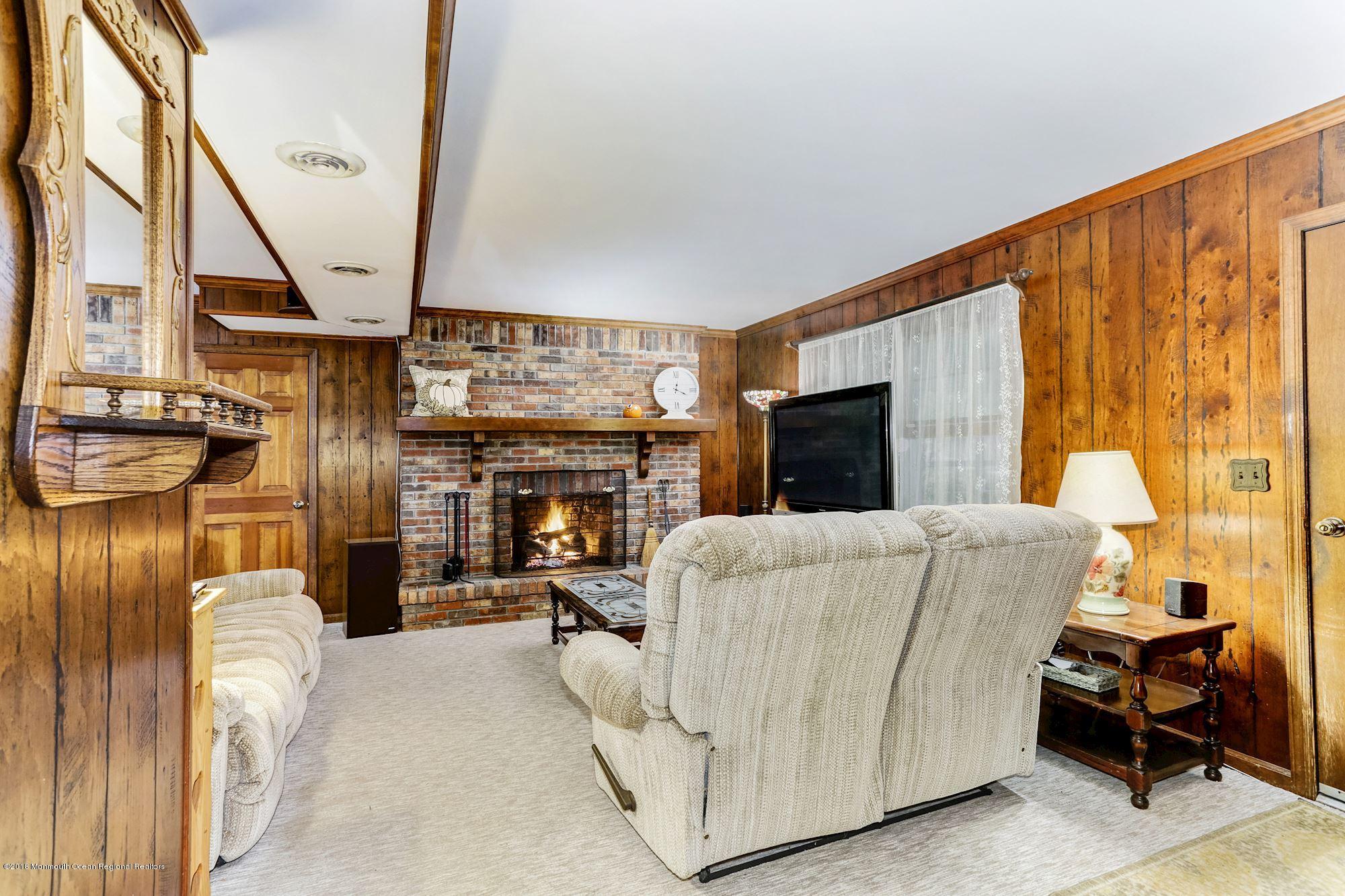 3 East Point Road Lincroft, NJ 07738 - Photo 19 of 42 a living room with furniture a fireplace and a flat screen tv