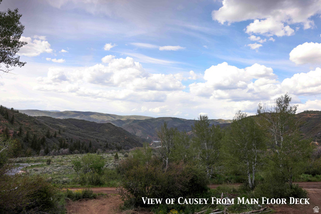 15253 Mill Road, Unit 62 Huntsville, UT 84317 - Photo 41 of 48 Expansive mountain landscape featuring rolling hills, mature trees, and a distant body of water under a partly cloudy sky