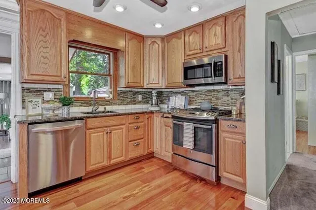 a kitchen with stainless steel appliances granite countertop a stove a sink and a microwave