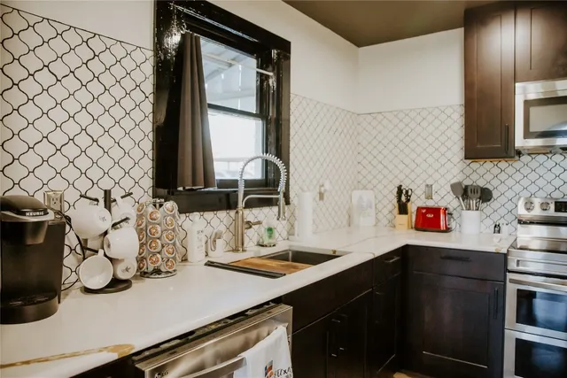 a kitchen with a sink and a stove with wooden floor