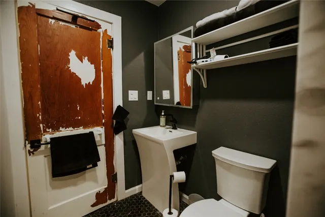 a bathroom with a toilet a sink and mirror