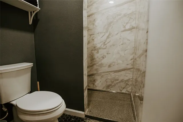 a white toilet sitting next to a shower