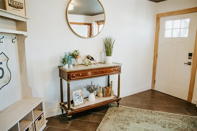 a room with painting on the wall and a mirror