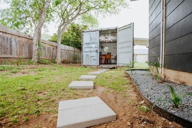 a view of backyard with wooden fence