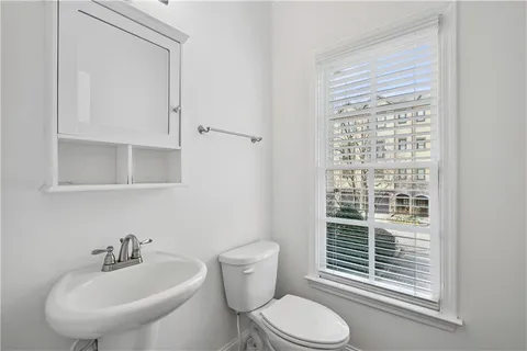 a bathroom with a sink a toilet and a mirror