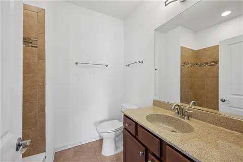a bathroom with a granite countertop sink toilet and shower