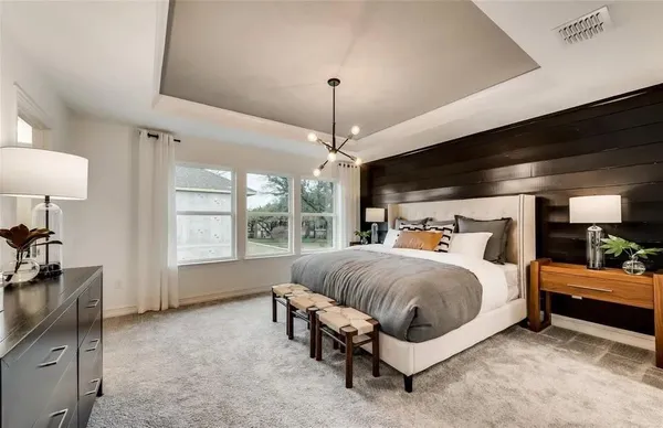 a spacious bedroom with a bed and a chandelier