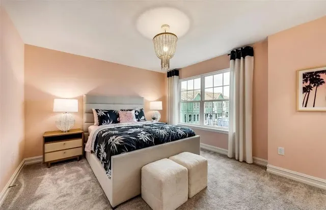 a bedroom with a large bed and a chandelier