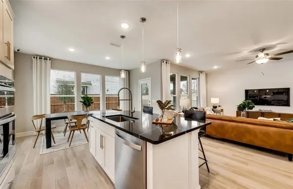 a kitchen with sink refrigerator and couches