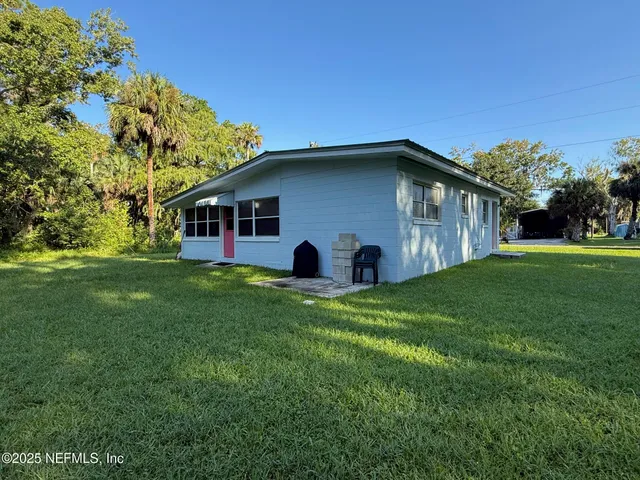 an aerial view of a house with a yard and lake view