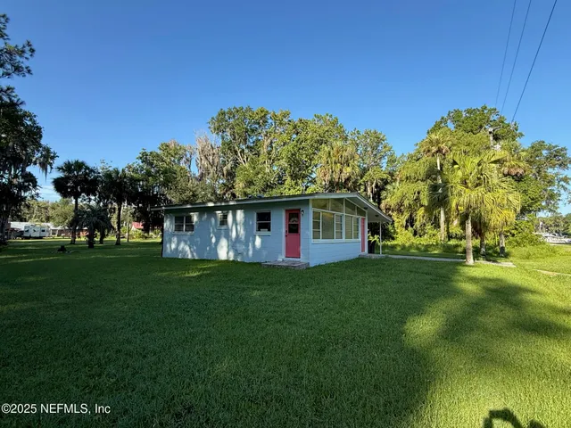 an aerial view of a house with a yard and lake view