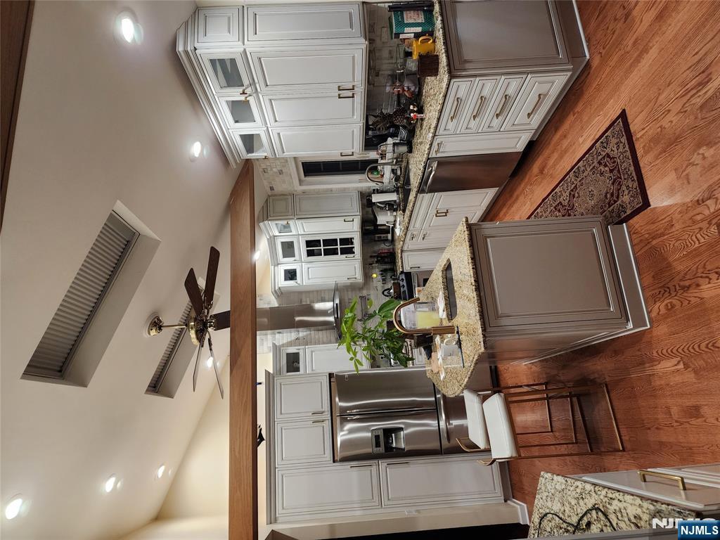 a kitchen with stainless steel appliances kitchen island granite countertop a sink stove and refrigerator