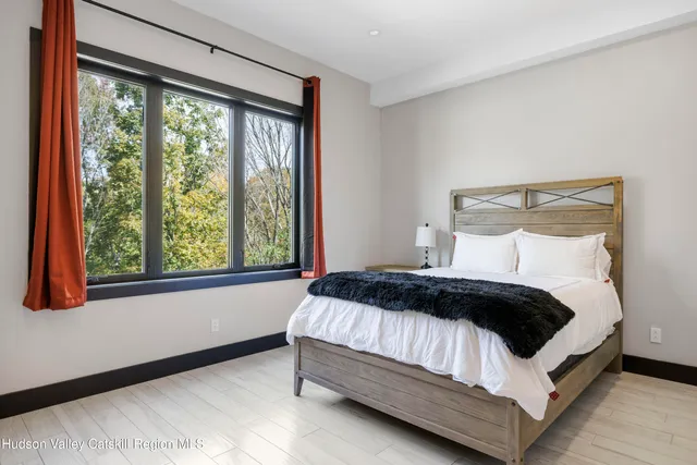 a view of an empty room with wooden floor and a bathroom