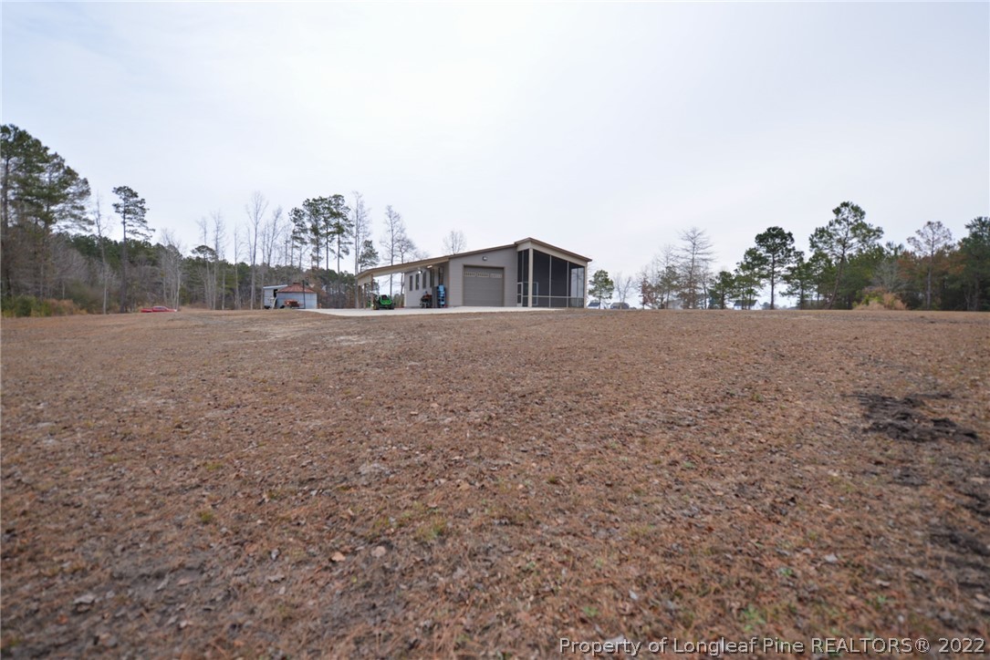 5671 Stewart Road Godwin, NC 28344 - Photo 43 of 45 a view of a house with a yard and large trees