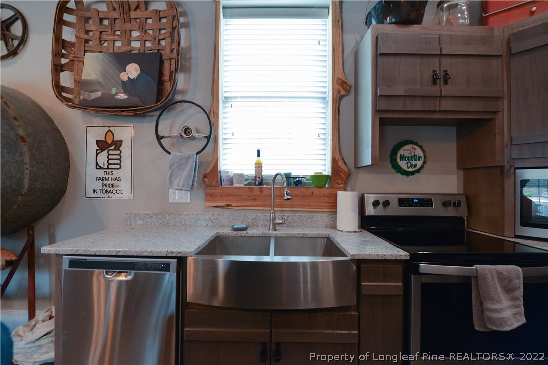 5671 Stewart Road Godwin, NC 28344 - Photo 5 of 45 a living room with furniture a clock and a fireplace
