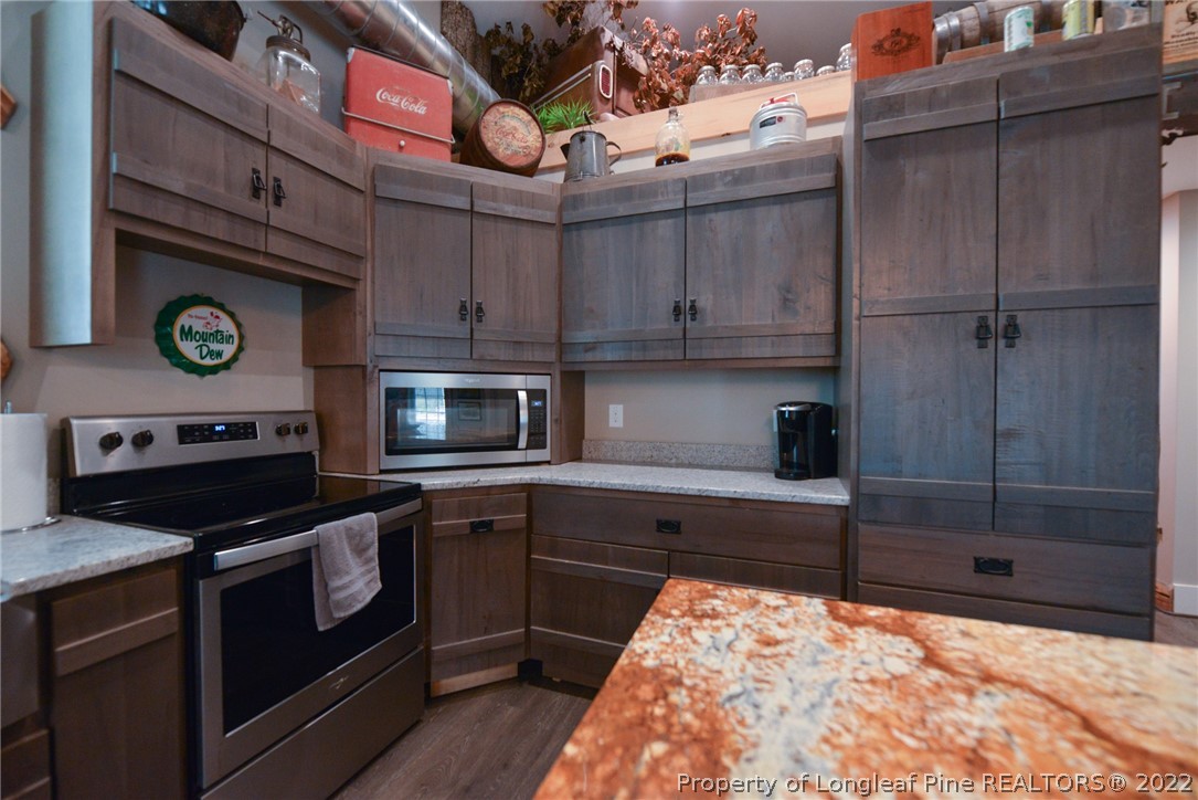 5671 Stewart Road Godwin, NC 28344 - Photo 9 of 45 a kitchen with stainless steel appliances granite countertop a stove and a refrigerator