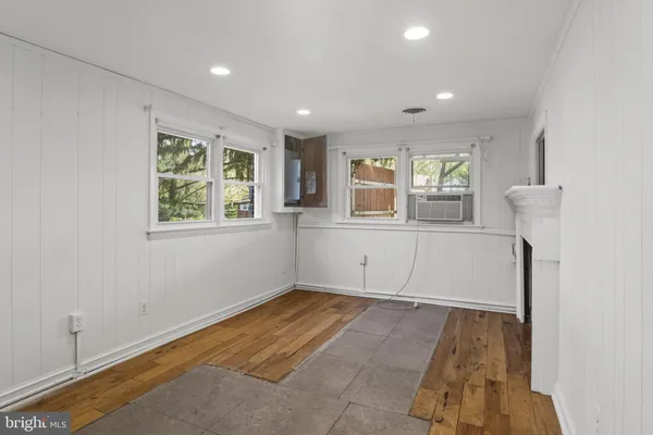 a view of empty room with window and wooden floor