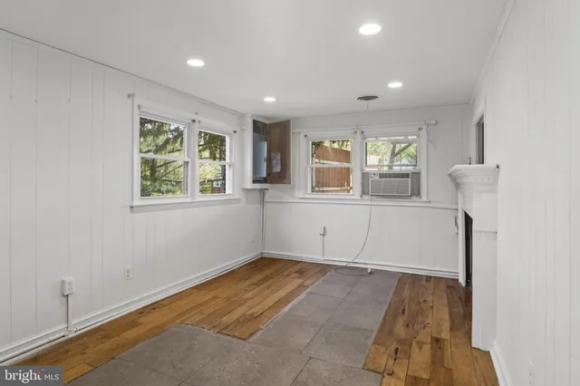 a view of empty room with window and wooden floor